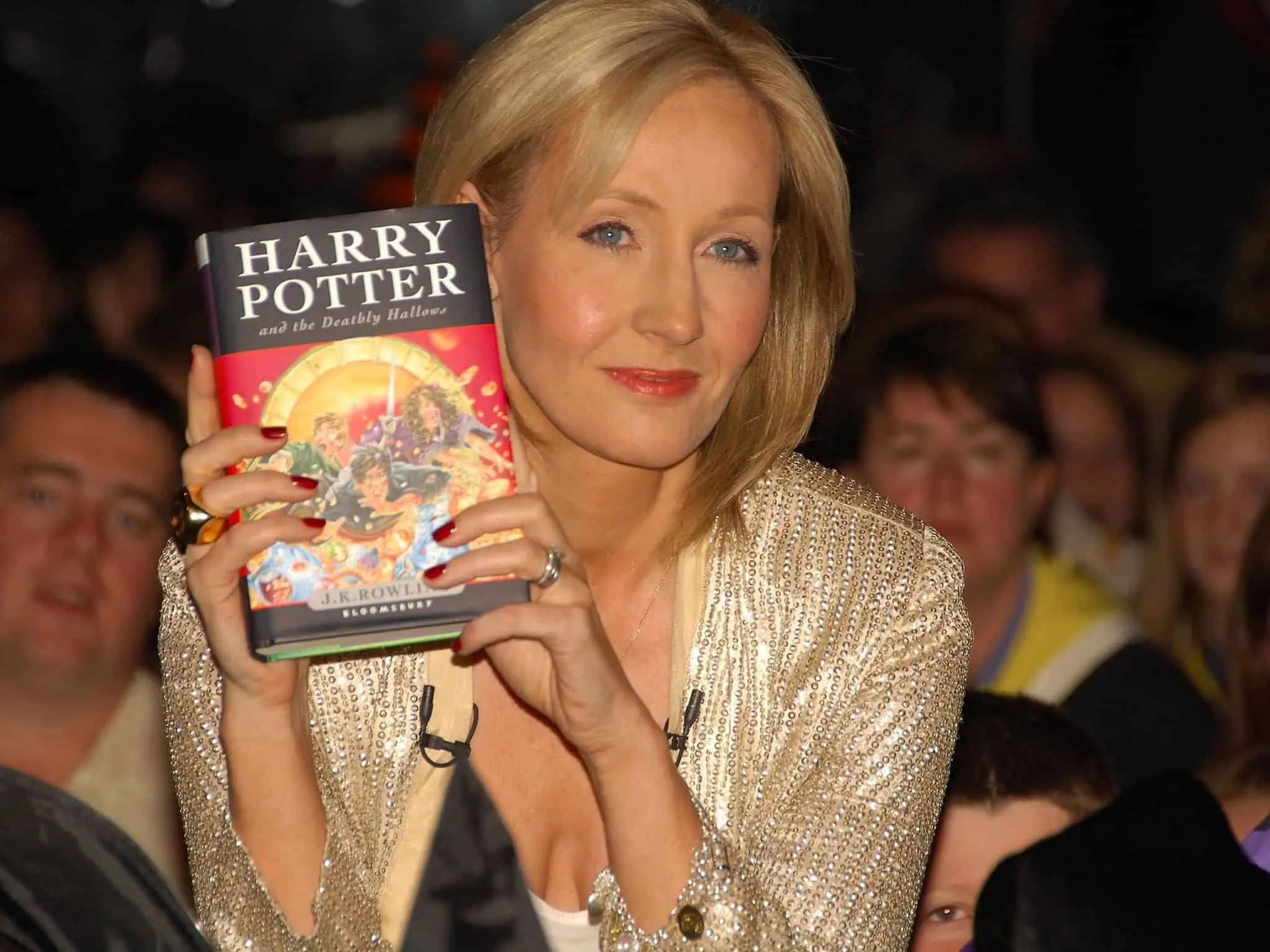 JK Rowling segurando livro de Harry Potter